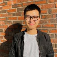 Wanheng standing in front of a brick wall